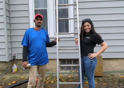 A photo of two colonial remodeling roofing experts holding a ladder